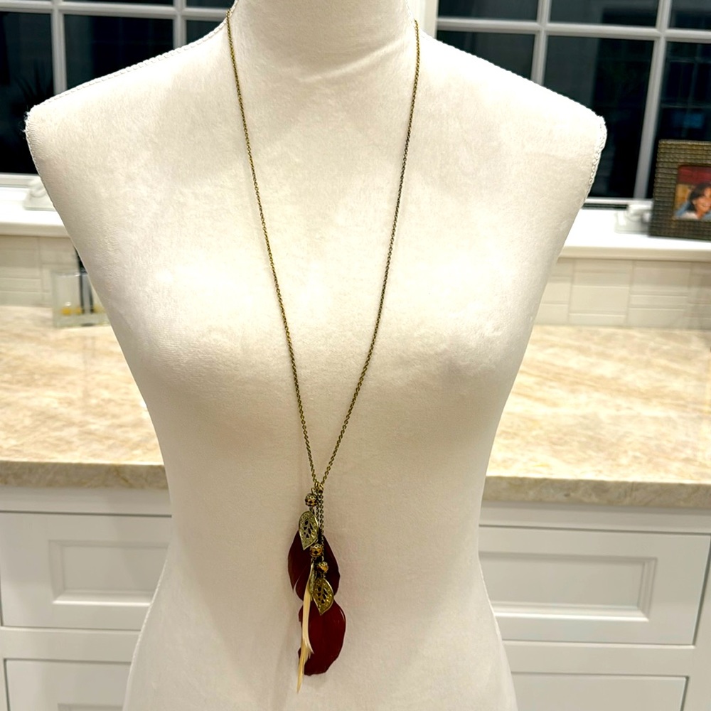 Feather and gold tone necklace
